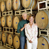 old couple standing with barrels